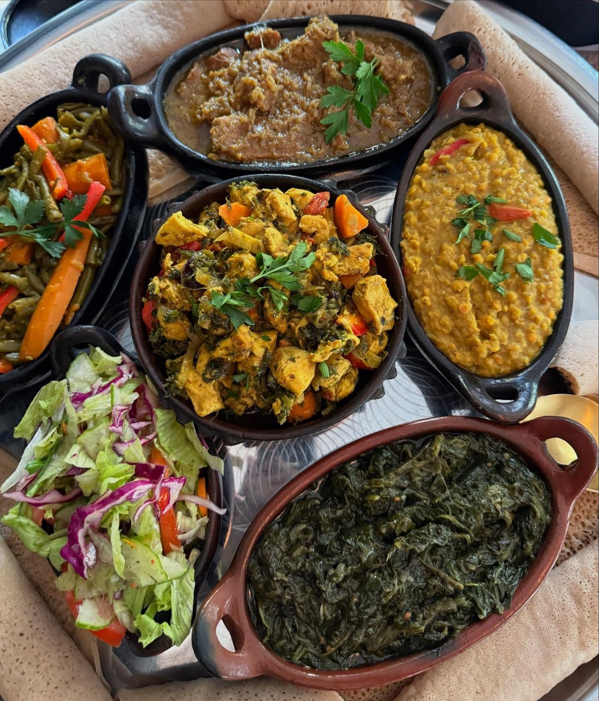 Various Ethiopian stews in cast iron dishes